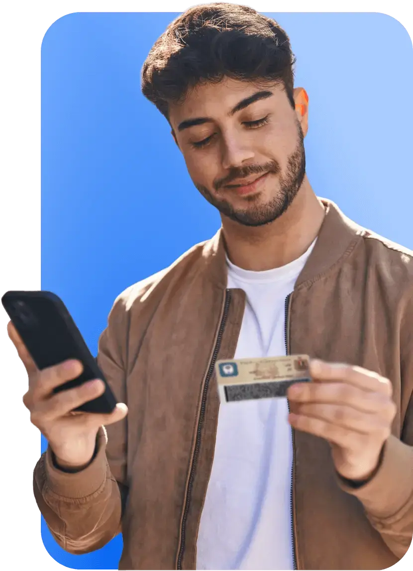 A man looking at card while holding a phone